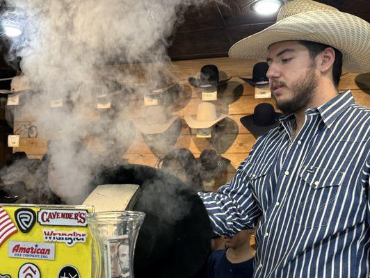 Jacob showing the kids the process of steaming a hat