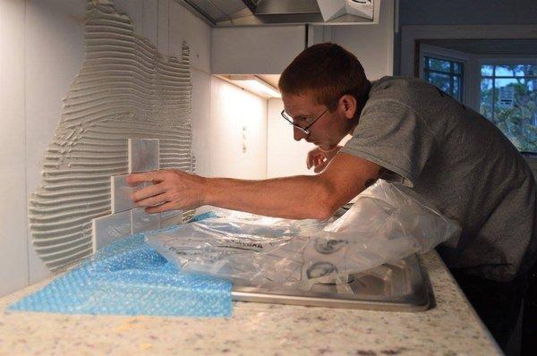 Jesse Overton installing kitchen backsplash