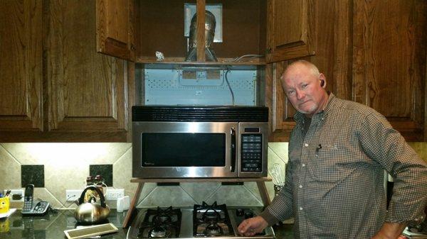 Larry working on a built-in microwave unit and gas range.