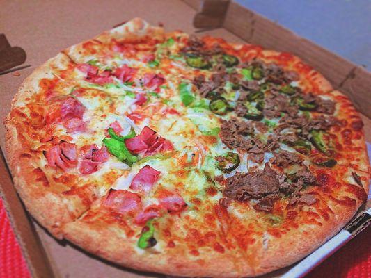 Pizza with green peppers, onions, ham, steak, and jalapenos.