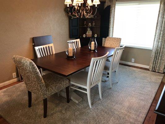 Dining room table and chairs, along with accent rug.