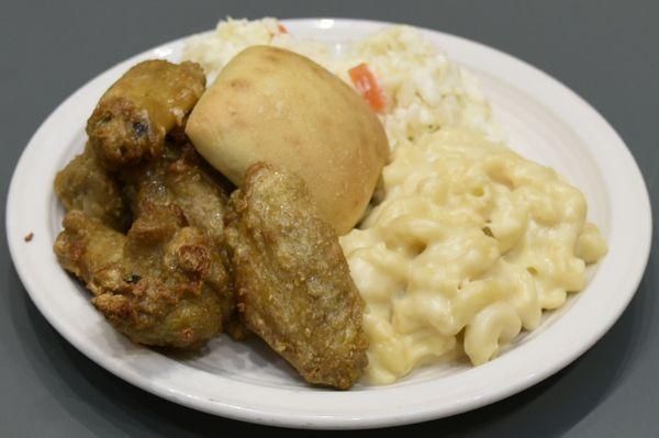 Chicken wings with macaroni and cheese and a side of coleslaw.