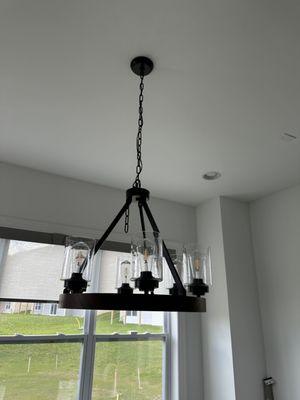 Connecting a new electrical line above the dining area and installing a heavy light fixture on a drywall ceiling.