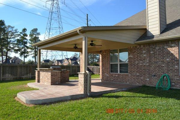 Covered patio addition with outdoor kitchen and stamped concrete located in Spring Creek Oaks