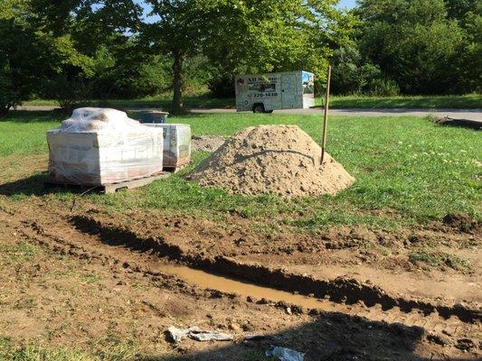 No tarp under sand and gravel piles.   Deep rut cut into lawn.