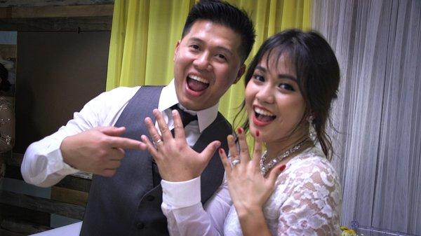 Bride and groom show off their wedding rings.