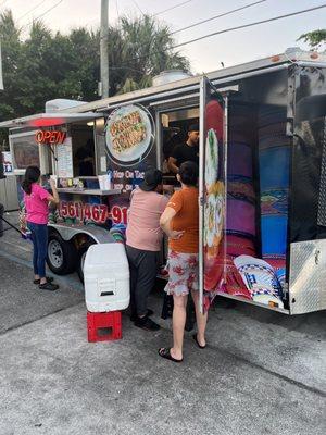 The food truck sits on the side of the mobile gas station