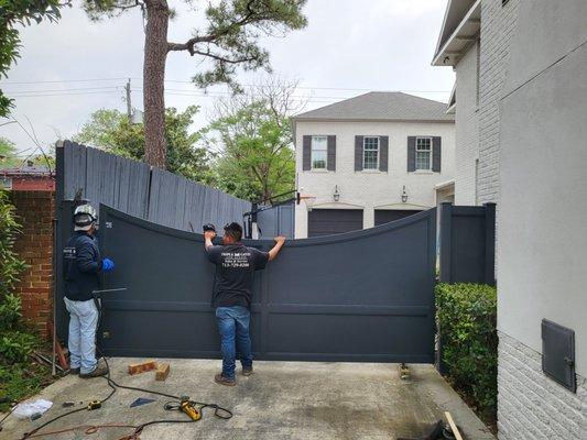 Newly fabricated swing gate being installed by the team.