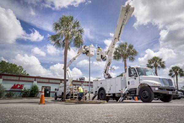 East-West Electric bucket trucks installing LED lighting at ACE HARDWARE.