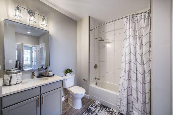 Bathroom with gray shaker cabinet vanity and white quartz countertop.