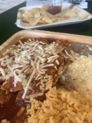 3 chicken enchiladas with red sauce, rice, refried beans, chips and salsa.