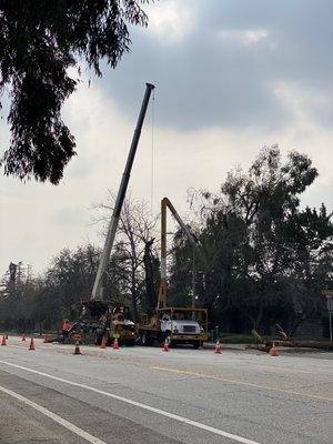 Wind damage 2022 using a crane to pull a tree off a home