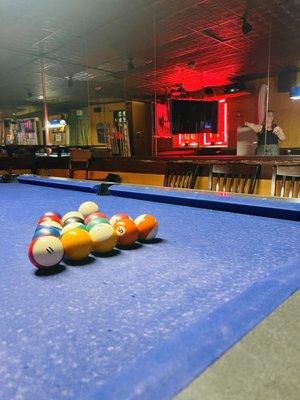 A proper dive bar has neon, mirrors, pool, and unmatched chairs.