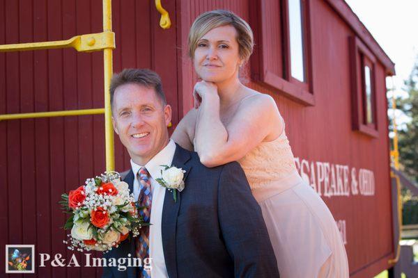 Bride and groom in front an old-fashioned train car In Metro Detroit