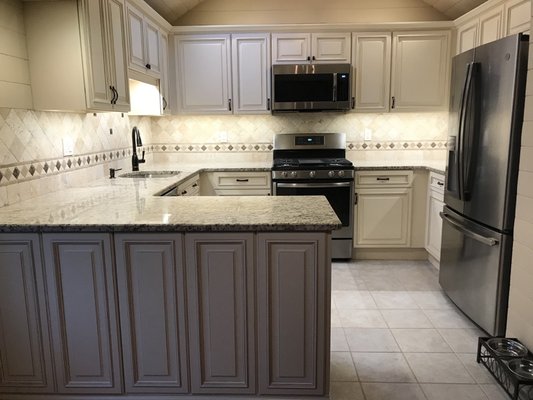 Stock Fabuwood Cabinetry, Classic Wellington Ivory/Glaze, 84" tall, decorative back panels. Backsplash is Chiaro Tumbled Tavertine, border i