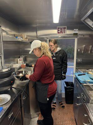 Josie teaching Suzie how to cut and fry the chips.