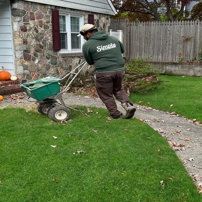 Lawn care professional fertilizing a lawn.