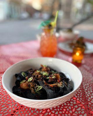 squid ink hand pulled noodles with crab, shrimp, cream + chili