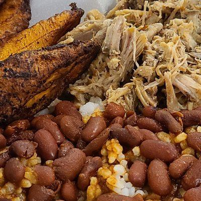 Close-up of Rice and beans, roast pork, and sweet ripe plantains.