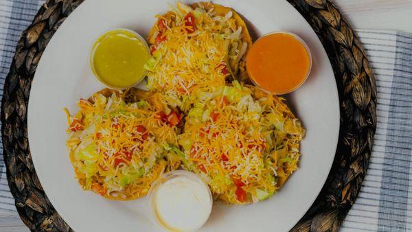 3 fried crispy tortilla layered with refried beans and topped with steak or chicken, lettuce, tomato, and cheese (includes cream and avocado