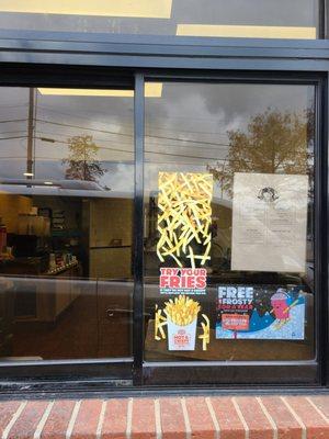 Posted sign of store hours...no employee in sight... ignoring cars in drive thru