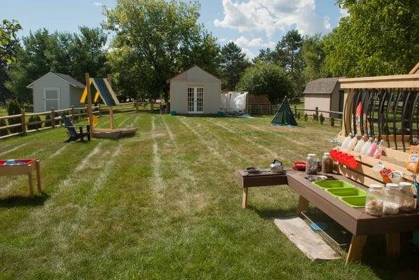 Outdoor area with  mud kitchen and reading nook and science lab in