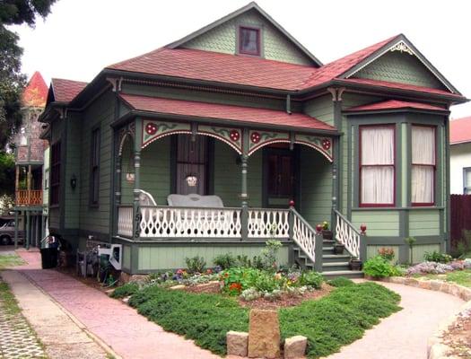 This sweet Queen Anne Victorian cottage is our home; and, also our logo. Behind our house is our duplex vacation rental.