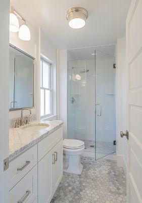 Marble and white cabinetry brighten an upgraded master bath in an older home.