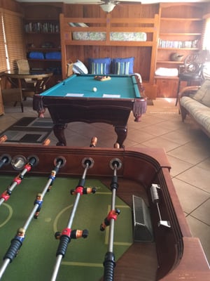 Large game room with built in bunk beds, futon, pool table, foosball, darts, private bathroom with tiled walk in shower.