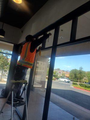 Removing Stickers from Window at Reborn Coffee Shop at Laguna Hills