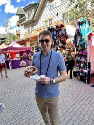 Husband with his big pretzel, beer cheese and cute little beer sampling glass and it's holder