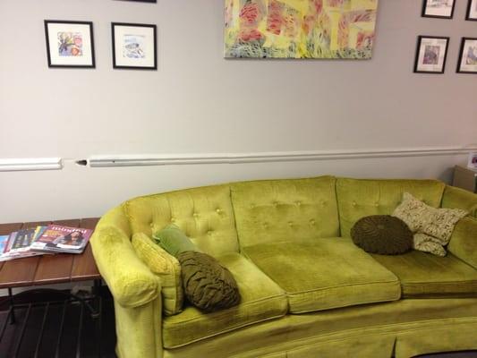 The waiting area with vintage couch and artwork