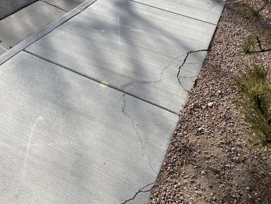 Sidewalks cracked during landscaping, marked for replacement yet still in this condition years later.