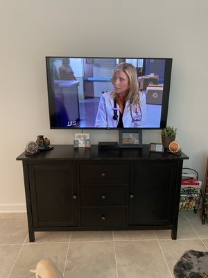 Tv installation with a full motion mount and cable box setup.