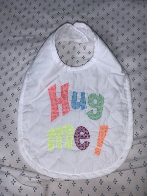 Here is a baby bib for any cute little angel and it says "Hug Me!"