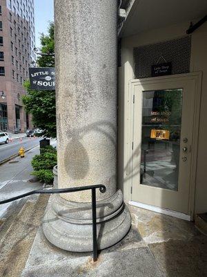 Entrance is hidden behind this column at the top of the stairs