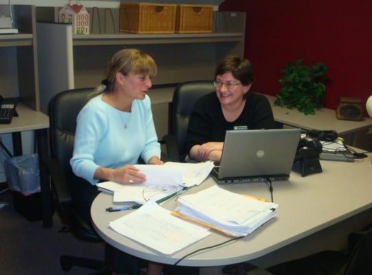 Susie Cammett and Dana Voelzke working on a short sale packet.