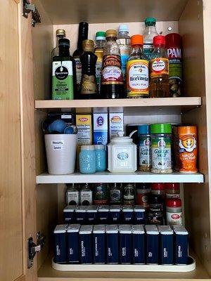 A small cupboard can hold a lot more if the spices and oils are placed on tiered shelves.