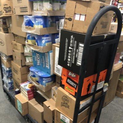 Food items randomly stacked with books and trash.