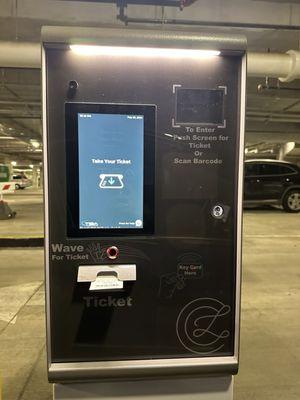 You have to take a ticket from the kiosk to enter the underground garage where the Tesla Superchargers are