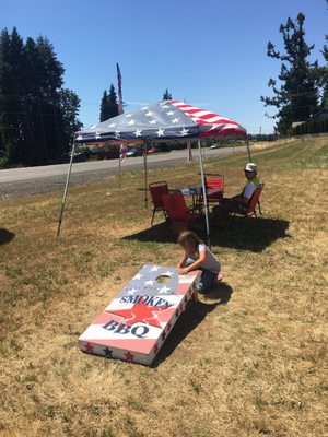 Table under canopy and corn hole