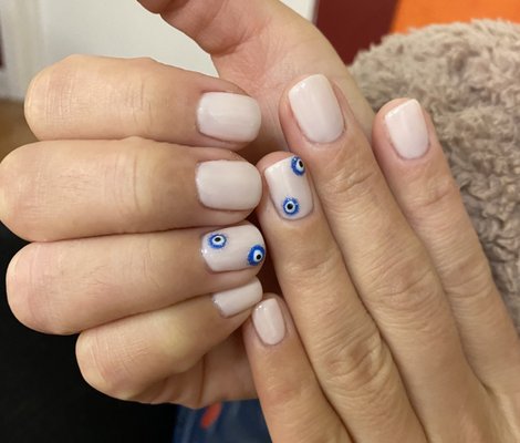 Gel manicure with evil eye design