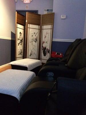 Reflexology room with recliners and subdued lighting.