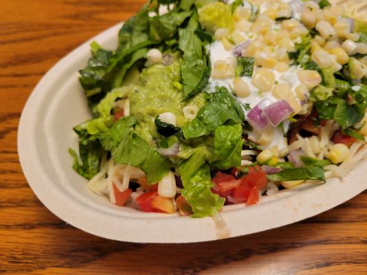 White rice, steak, fajita veggies, corn salsa, pico de gallo, cheese, sour cream, lettuce and guacamole.