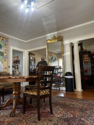 Old house living room transformed into a coffee shop. Decor is antique furniture and pretty murals