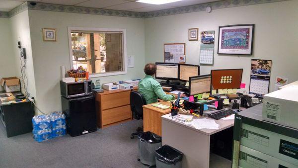 Jim at his desk, 2018. Free cold water for the UPS and FedEx drivers.