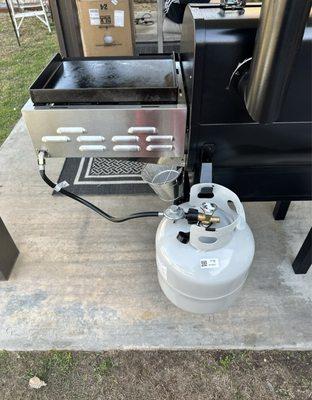 Propane tank for the sidekick burner/griddle comes with a hanger for the tank...Now he can feed his 80 kids with bbq!! LOLOL!!