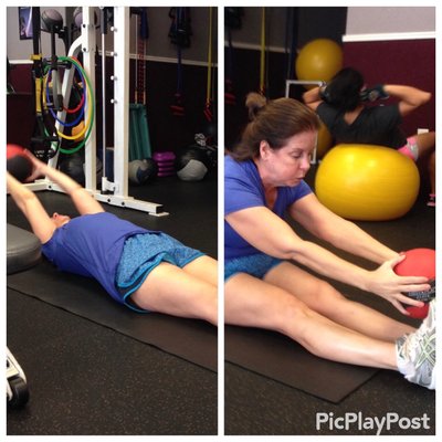 Mary doing Roll Ups with a weighted ball