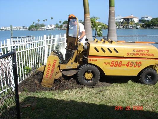 Grinding a stump next to a fence