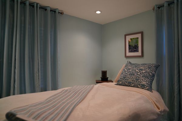 Massage room with thoughtful addition of a little waterfall element and comfortable massage bed.